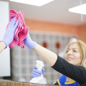 Woman at work, professional maid cleaning in office against virus desease